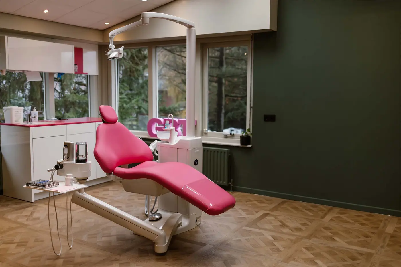 Onze lichte behandelkamer met roze behandelstoel